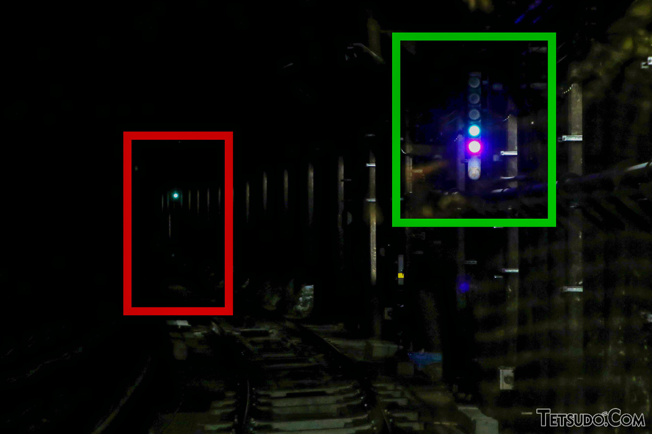 紫色のランプがあるトンネル区間の中継信号機（緑枠の部分）。左奥の信号機（赤枠の部分）が青であることを示しています