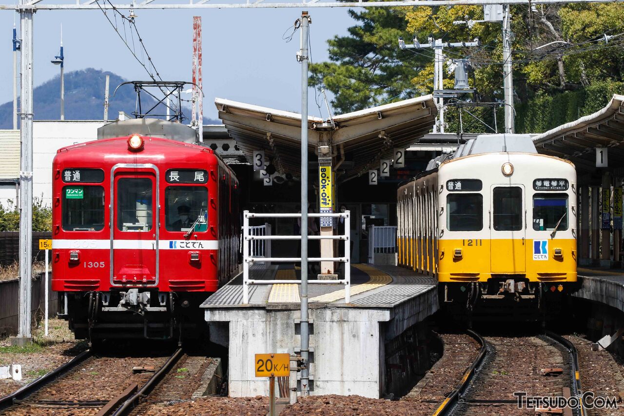 高松築港駅で発車を待つ「追憶の赤い電車」（写真左）。京急時代からの僚友である1200形（元・京急700形）と顔を並べます