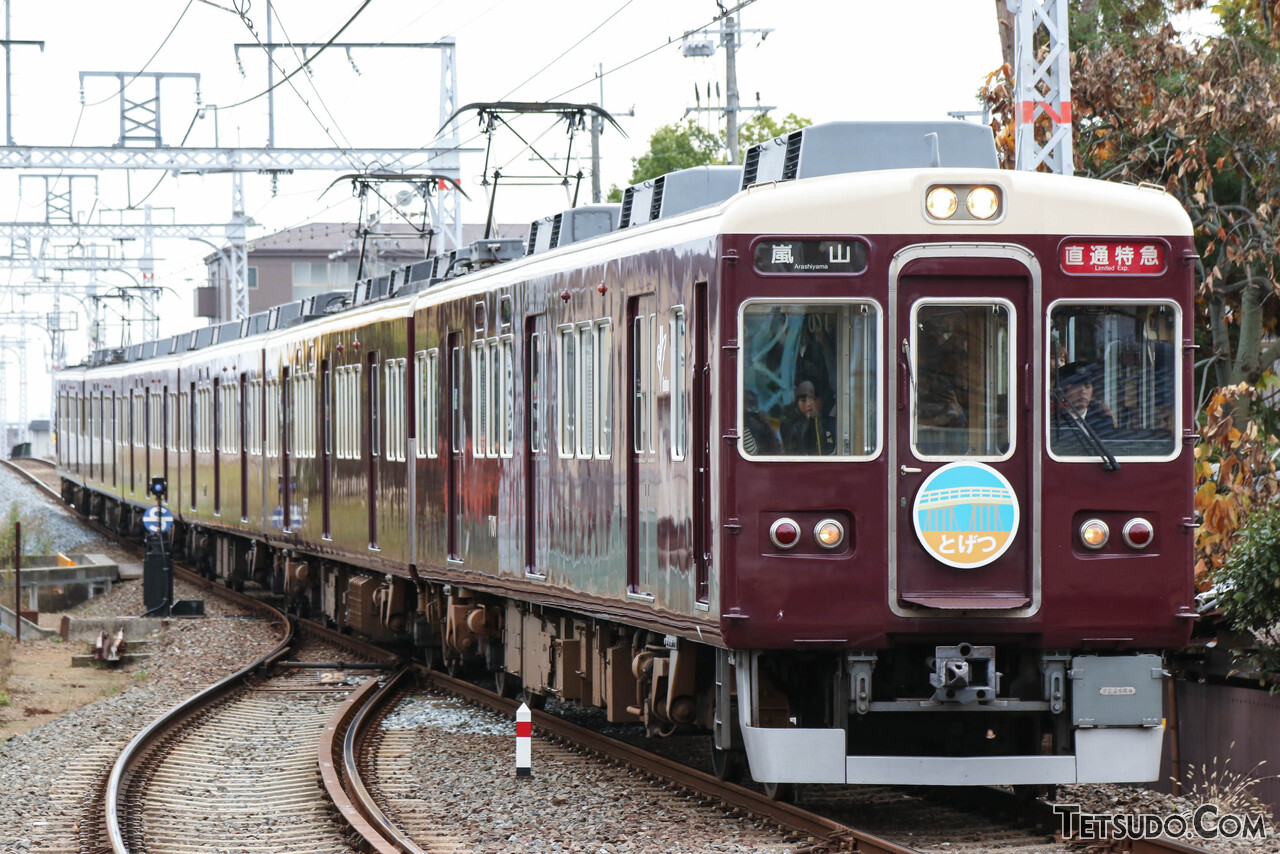 専用ヘッドマークを掲げる7000系の直通特急。「とげつ」は宝塚駅発着列車の愛称です
