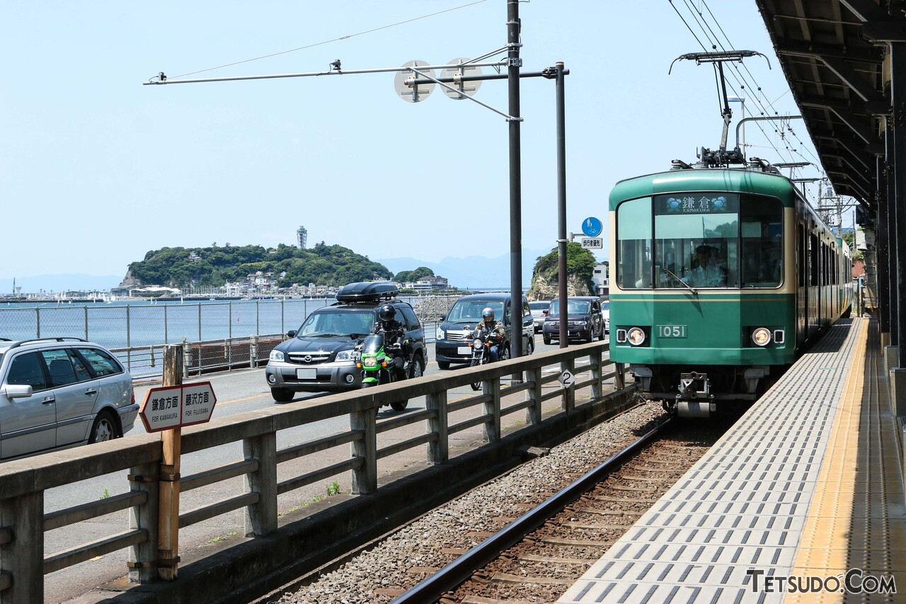 関東の一大観光地のひとつ、江の島を背景に走る江ノ電