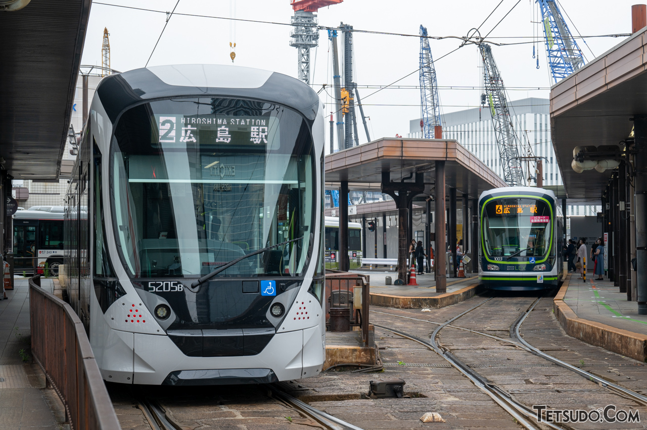 広島電鉄の5200形「Green Mover APEX」（左）と1000形「GREEN MOVER LEX」（右）。ともに「ICカード全扉乗降サービス」の対象車両です（写真はサービス開始前に撮影）