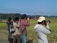 総武本線沿線で、走行する列車を撮影する参加者と鉄道写真家・広田泉氏