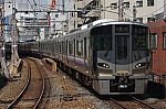 ビルの合間を抜けて天満駅に到着する223系5100番台(HF442編成)