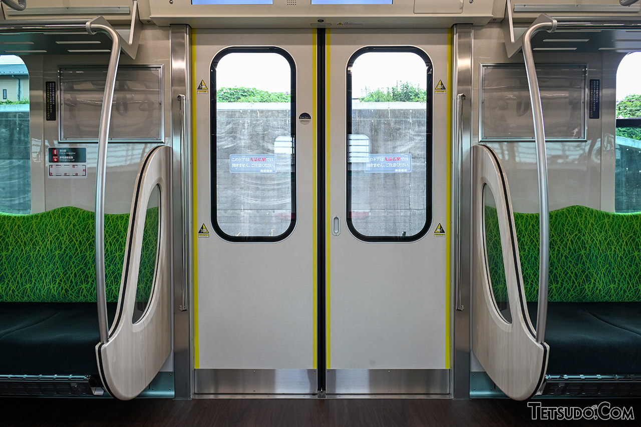 車内ドア付近。ドア脇の手すりはシンプルな形状に変更されています