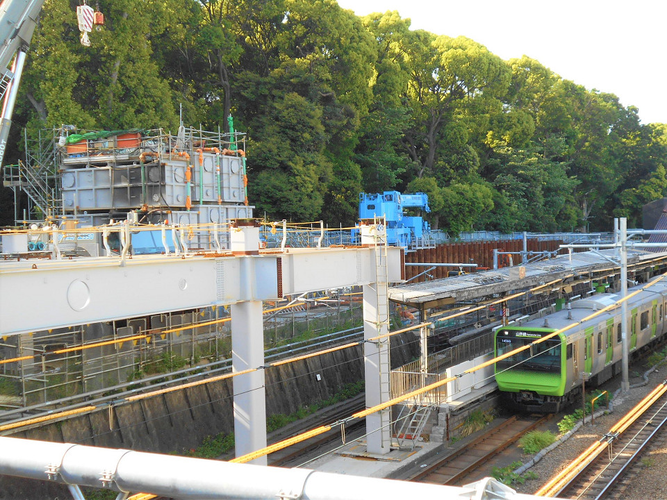 新しい駅舎は、線路をまたぎ、現ホームと工事中の臨時ホームの南側上部にわたる範囲で建設。ホームの南端には、駅舎を支える柱が設置されています。写真左の明治神宮側には、新たな出入口として「明治神宮口」も設けられます。エレベーターは、明治神宮口、表参道口の両方に設置される予定です。